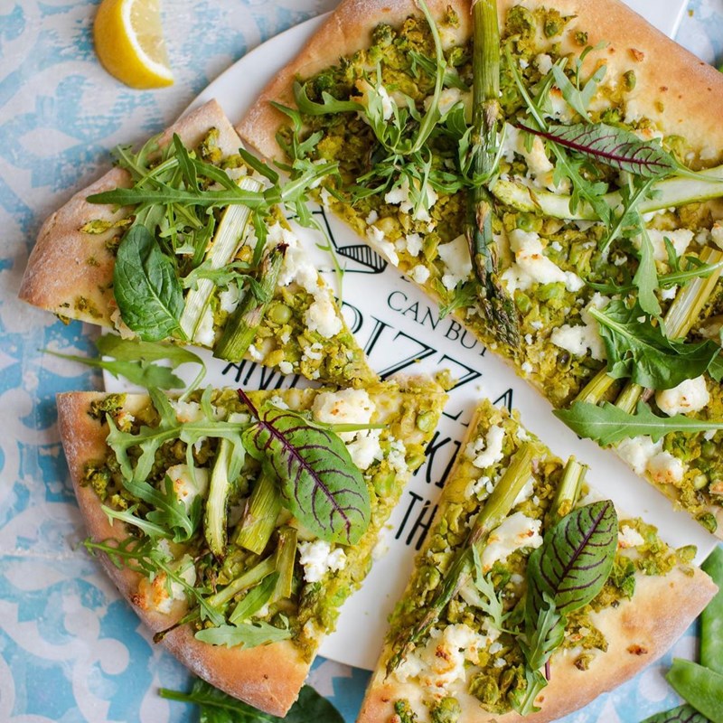 Spring pizza with green peas, goat cheese and herbs